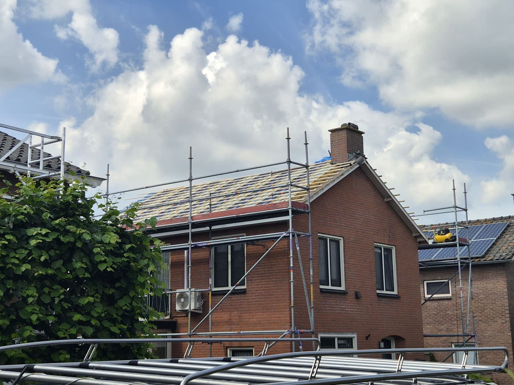 Steiger rondom, nieuwe panlatten op de renovatieplaten