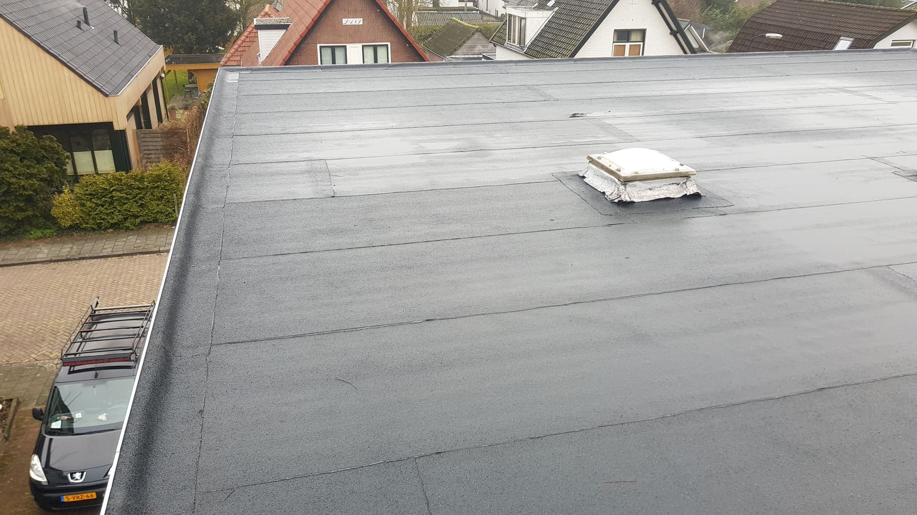 Hetzelfde platte dak met nieuwe bitumen dakbedekking, strak opgeleverd