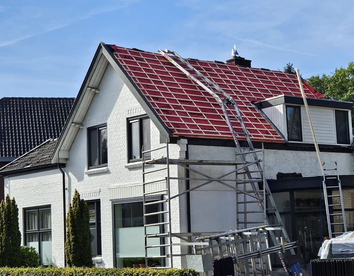 Oude pannen en latten eraf, de nieuwe waterdichte folie ligt op het dak